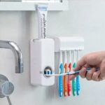 Toothpaste dispenser with an attached toothbrush holder